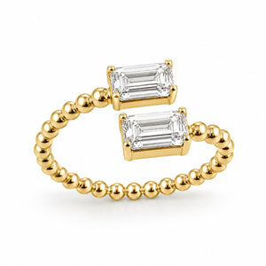 Gold ring with emerald-cut gemstones on a white background