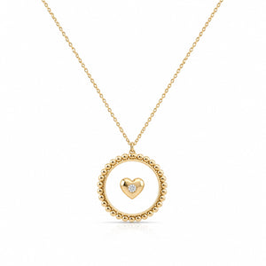 Gold necklace with a heart-shaped pendant on a white background