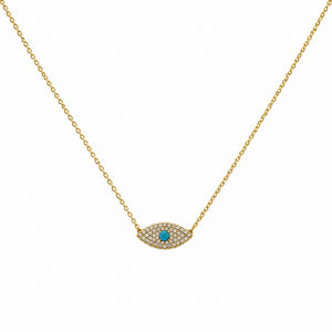 A delicate gold chain necklace featuring an evil eye pendant paved with small clear stones and a central turquoise blue gemstone, shown against a plain white background.