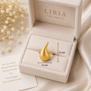 Gold ring in a LIRIA jewelry box with a motivational card and flowers.