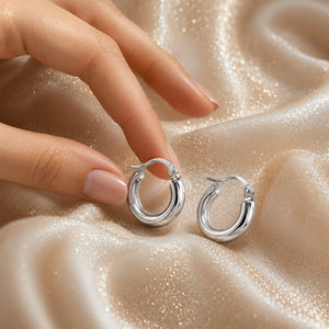 A pair of polished 18k white gold hoop earrings with a hinged clasp, displayed on a clean white background.