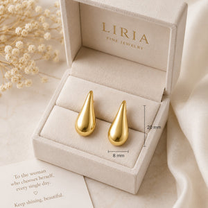 Gold teardrop earrings in a LIRIA jewelry box with dried flowers and a quote card.