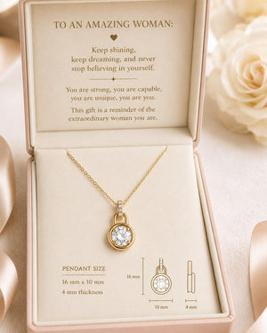 Gold necklace with pendant in a decorative box, featuring an inspirational message.