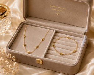 Gold necklace and bracelet in a jewelry box with 'Timeless elegance made for you' text.