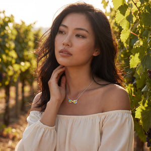 Woman in a vineyard wearing a necklace with a butterfly pendant