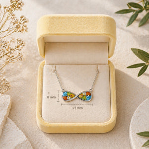 Colorful infinity necklace in a jewelry box with measurements on a natural background