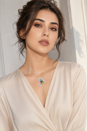 Woman wearing a necklace with a colorful pendant against a neutral background
