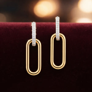 Gold hoop earrings with diamond accents on a dark background