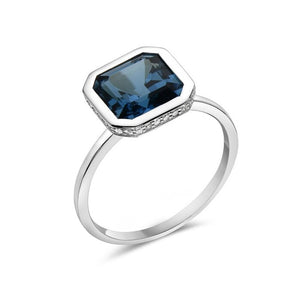 Silver ring with a blue gemstone on a white background