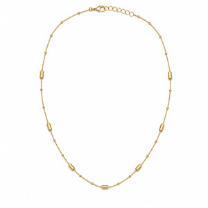 A delicate gold chain necklace with alternating small round beads and elongated barrel-shaped beads, displayed on a clean white background.