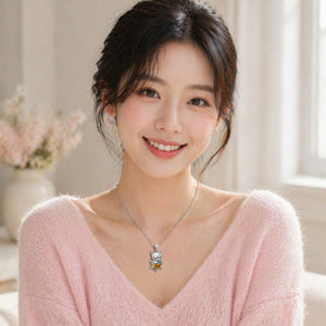 Woman wearing a pink sweater and a necklace with a colorful pendant indoors.