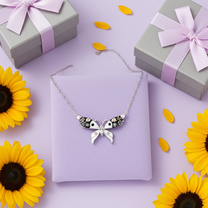 Butterfly necklace on a purple box with sunflowers and gift boxes in the background