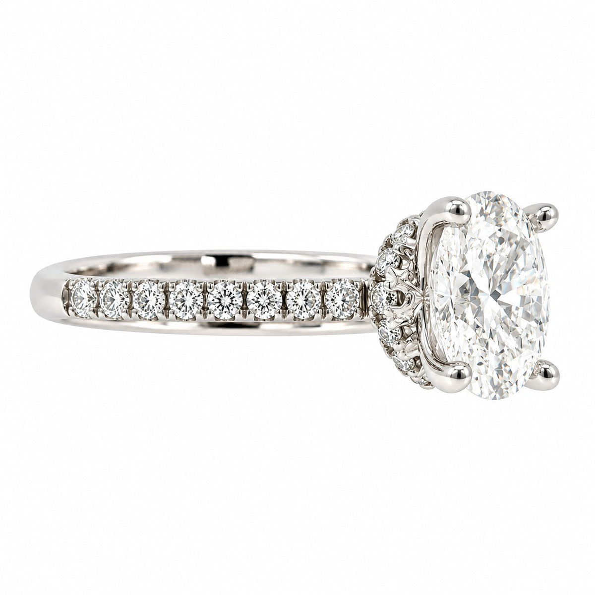 An oval diamond engagement ring in a silver-colored metal setting, featuring a halo of small diamonds and a pavé band with round diamonds, shown on a plain white background.