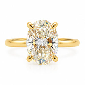 An oval diamond engagement ring with a yellow gold band, featuring a large oval-cut diamond set in a four-prong gold setting on a clean white background.