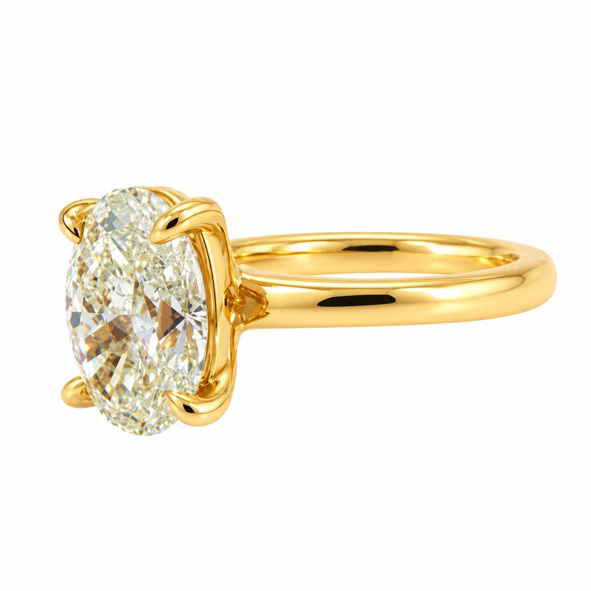 An oval-cut diamond ring set in a polished yellow gold band with a four-prong setting, shown on a plain white background.