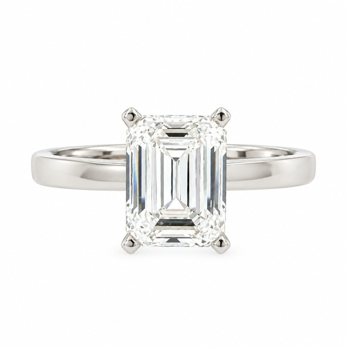An emerald-cut diamond engagement ring in a polished silver-colored metal band, set against a plain white background.