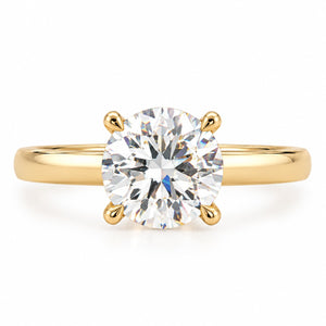 A classic solitaire engagement ring featuring a round brilliant-cut diamond set in a polished yellow gold four-prong setting, on a clean white background.