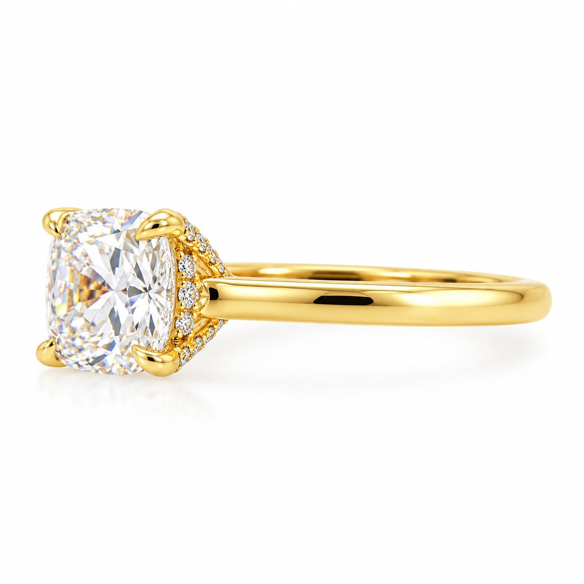 A yellow gold engagement ring featuring a large cushion-cut diamond center stone and a halo of small diamonds on the band, set against a clean white background.