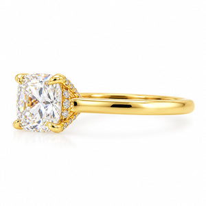A yellow gold engagement ring featuring a large cushion-cut diamond center stone and a halo of small diamonds on the band, set against a clean white background.
