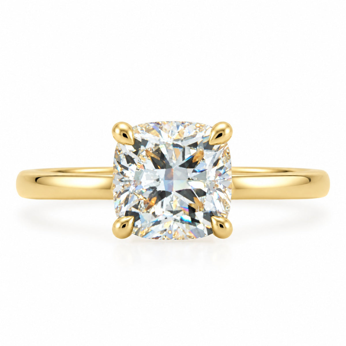 A yellow gold solitaire ring featuring a cushion-cut diamond center stone in a four-prong setting, shown on a clean white background.