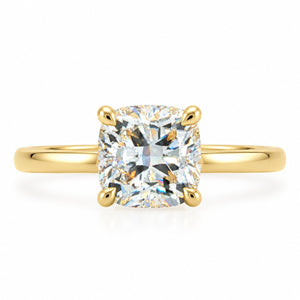 A yellow gold solitaire ring featuring a cushion-cut diamond center stone in a four-prong setting, shown on a clean white background.