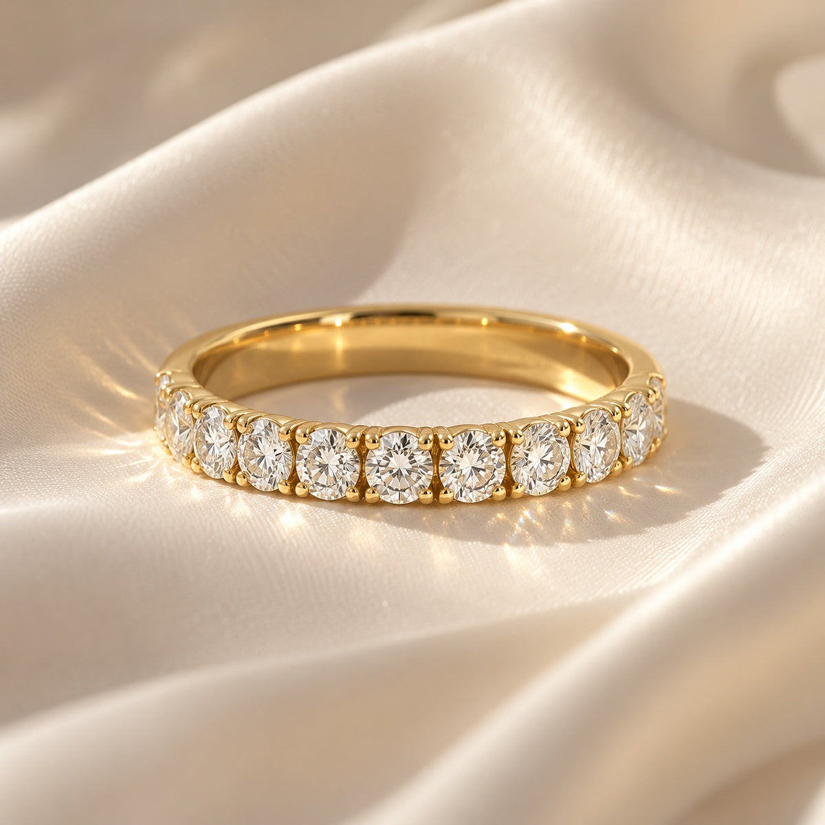 Elegant 14K yellow gold wedding band with 11 round lab-grown diamonds totaling 0.98 CT, displayed on luxurious ivory satin fabric.