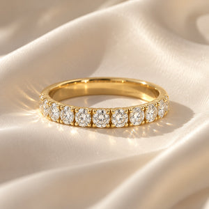 Elegant 14K yellow gold wedding band with 11 round lab-grown diamonds totaling 0.98 CT, displayed on luxurious ivory satin fabric.