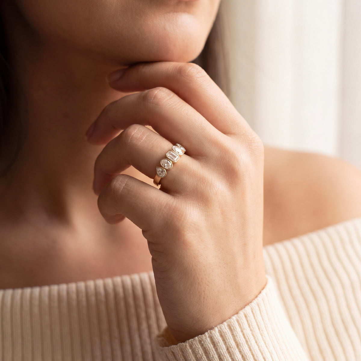 Close-up of a hand wearing a diamond ring with a blurred background