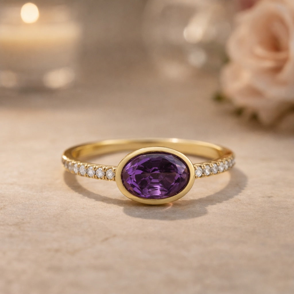 Gold ring with a purple gemstone on a beige surface with blurred background