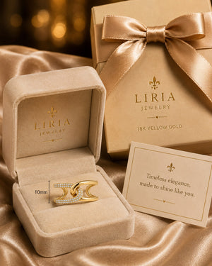Gold ring in a Liria Jewelry box with a branded gift box and card on a satin surface.