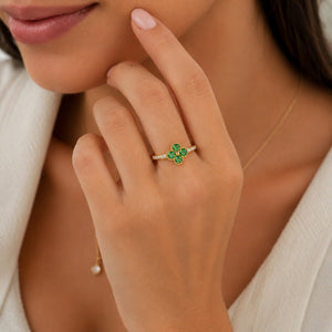 Gold floral ring with four green gemstones and diamond accents on the band.