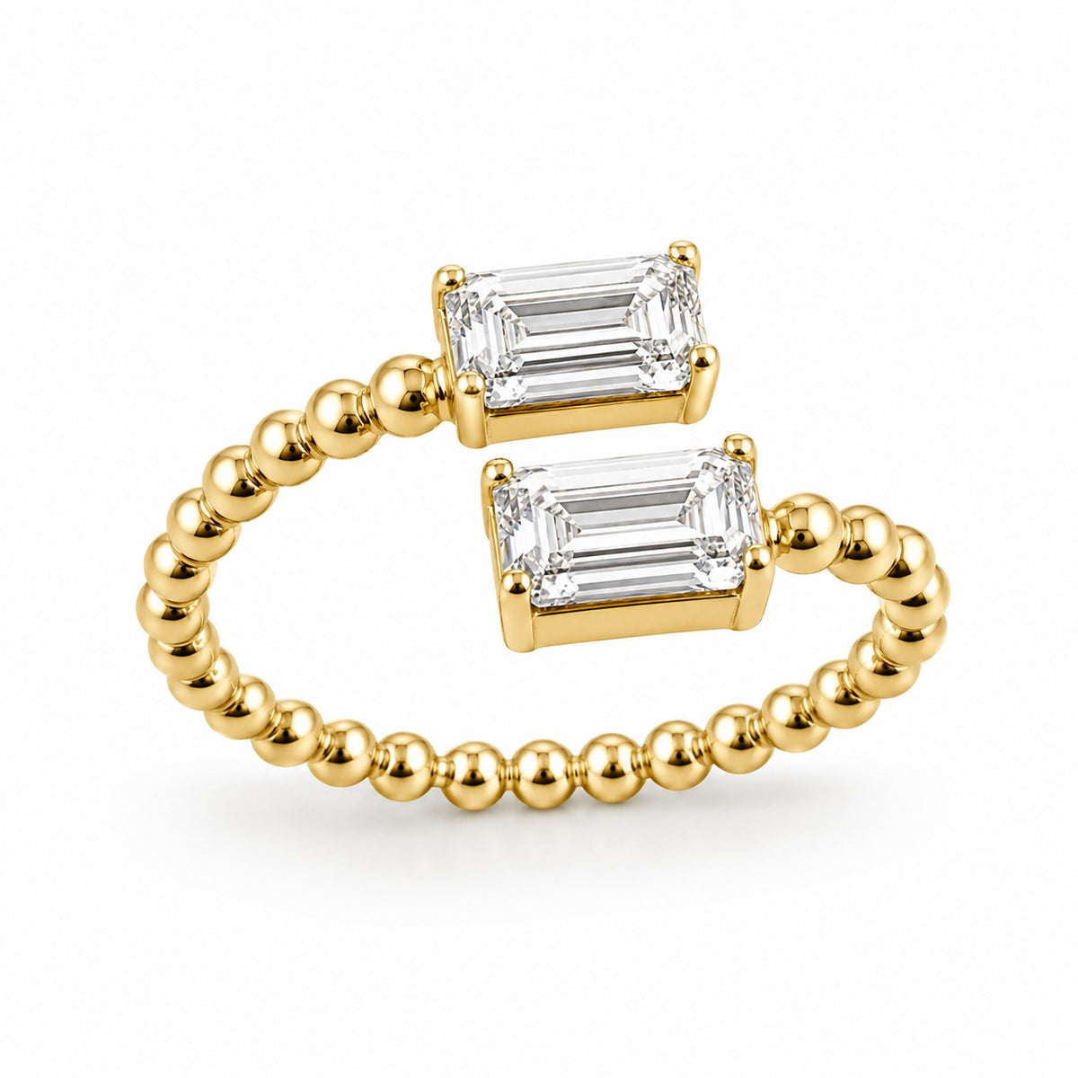 Gold ring with emerald-cut gemstones on a white background