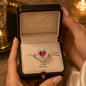 18K two-tone gold heart ring featuring two heart-shaped rubies surrounded by a yellow gold halo and an open white gold heart accented with sparkling diamonds.