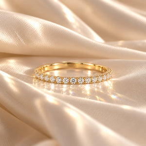 Delicate 14K yellow gold wedding band with 15 round lab-grown diamonds totaling 0.39 CT, resting on luxurious ivory satin with soft light reflections.