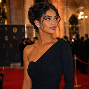 Woman in a black dress on a red carpet with a blurred background