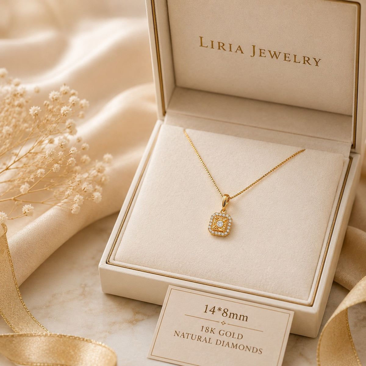 A gold pendant necklace displayed inside an open cream jewelry box. The pendant has a square shape with a halo of small clear stones and a central gold stone.