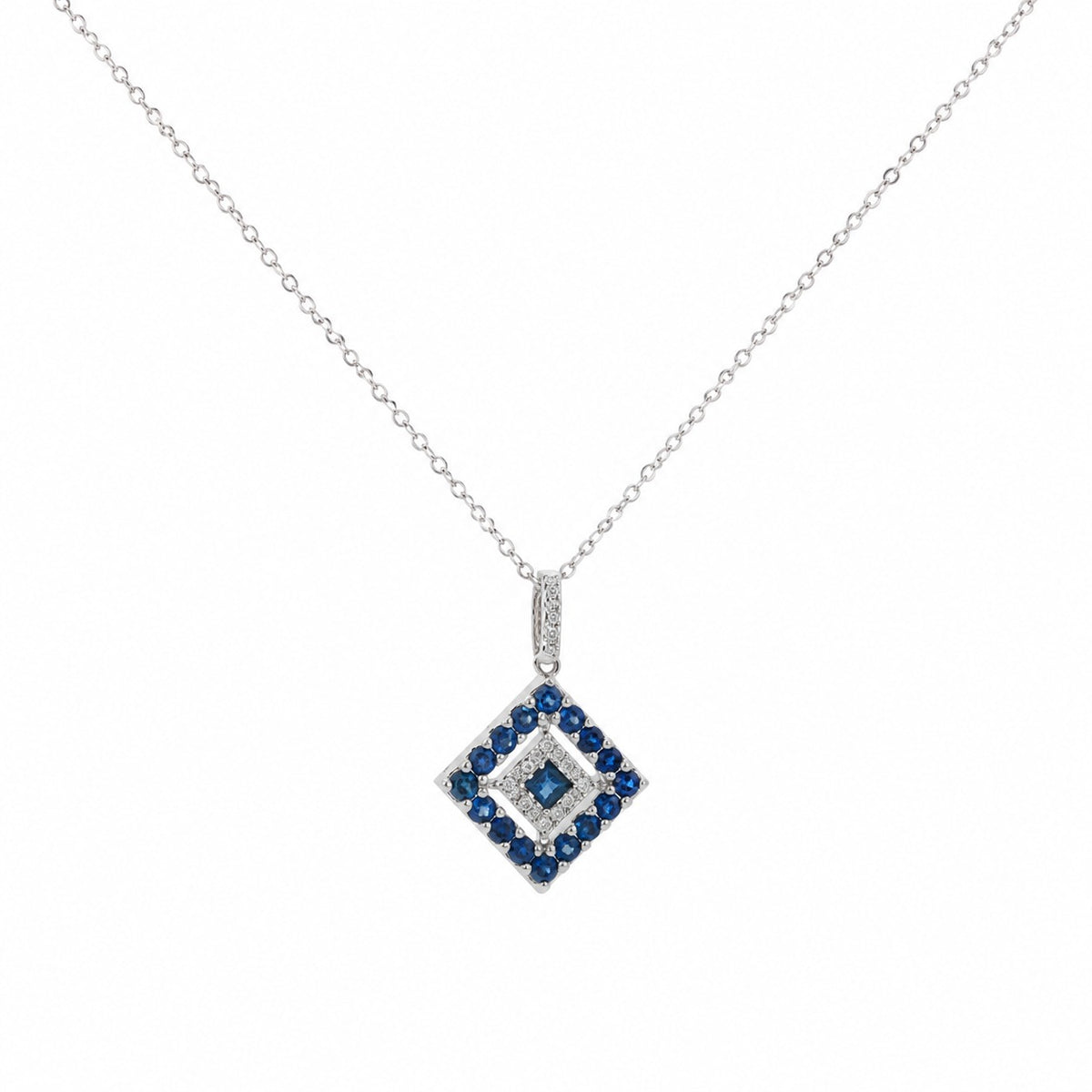 A delicate 14K white gold chain necklace featuring a geometric diamond-shaped pendant adorned with natural blue sapphires and sparkling white diamonds, displayed on a clean white studio background.