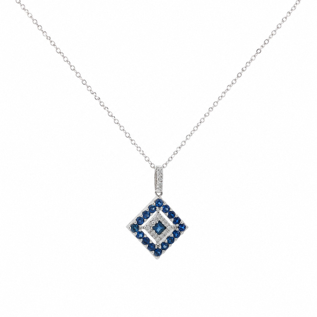 A delicate 14K white gold chain necklace featuring a geometric diamond-shaped pendant adorned with natural blue sapphires and sparkling white diamonds, displayed on a clean white studio background.