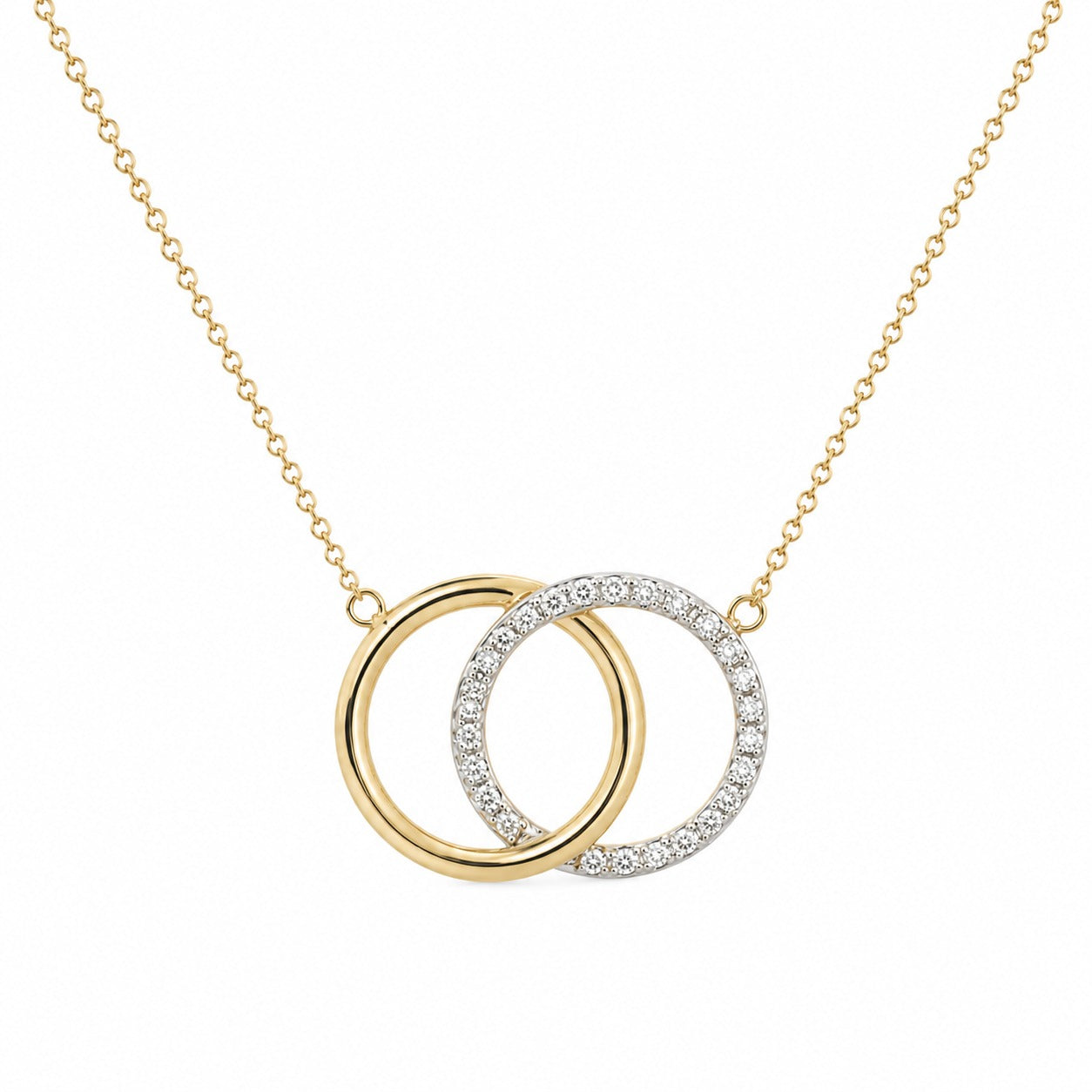 A gold chain necklace with two interlocking circular pendant rings, one solid gold and the other paved with small clear stones, shown on a plain white background.