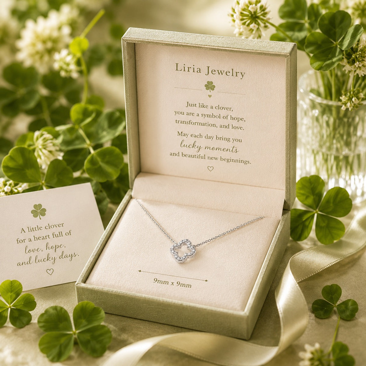 Liria Jewelry necklace in a box with clover leaves and a card in the background