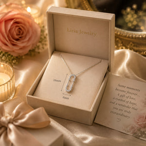 Silver necklace in a Lilia Jewelry box with a card on a decorative background