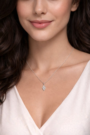 Close-up of a woman wearing a silver necklace with a diamond pendant.