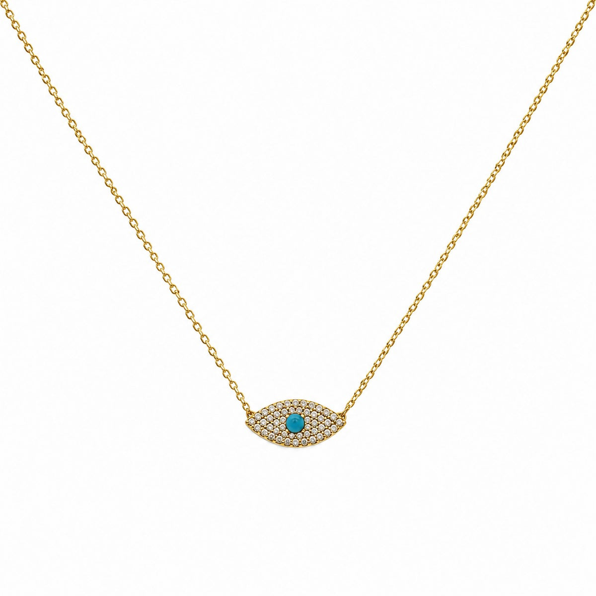 A delicate gold chain necklace featuring an evil eye pendant paved with small clear stones and a central turquoise blue gemstone, shown against a plain white background.