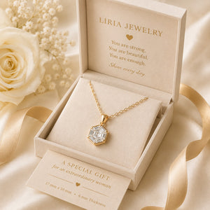 Gold necklace in Liria Jewelry box with decorative flowers and ribbon