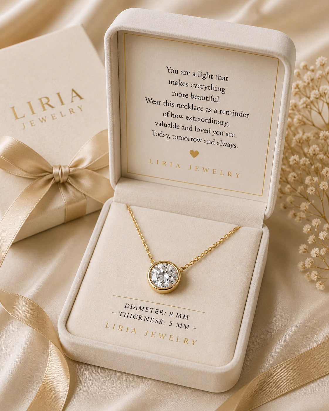 Gold necklace in Liria Jewelry box with sentimental message on a beige background