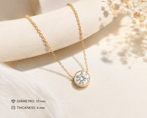 Gold necklace with a diamond pendant on a soft beige background