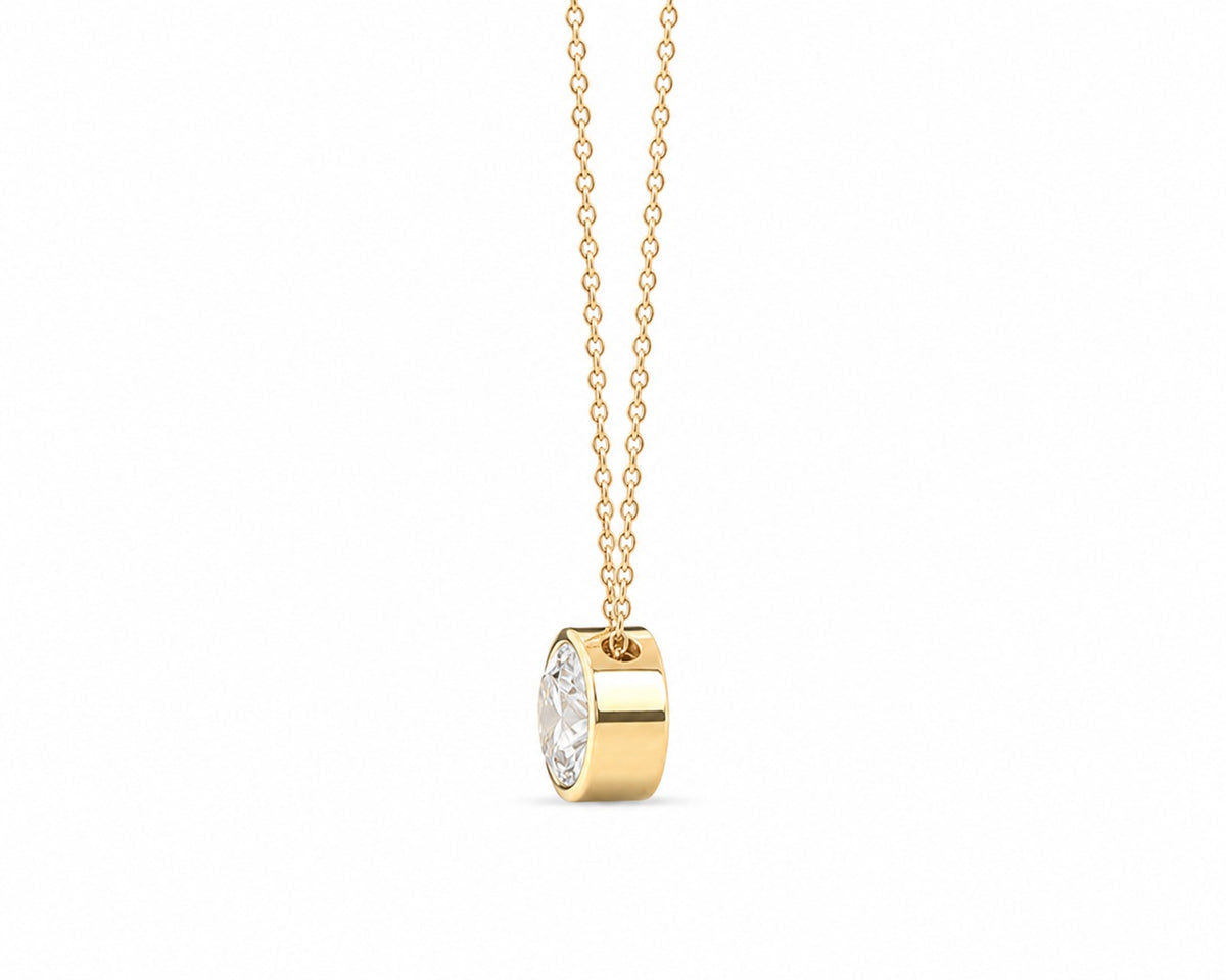 Gold necklace with a round pendant on a white background