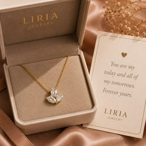 Gold necklace with a heart-shaped pendant in an open LIRIA Jewelry box on a satin surface.