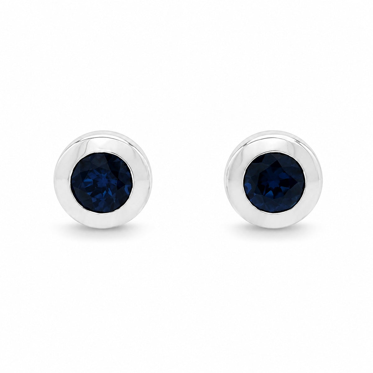 Pair of silver earrings with clear gemstones on a white background