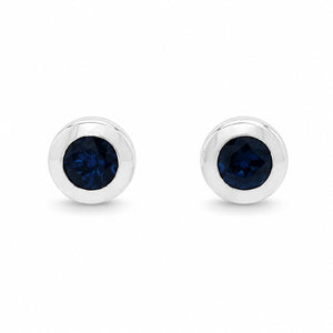 Pair of silver earrings with clear gemstones on a white background